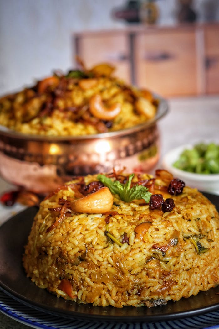 Mouth-watering Indian biryani served on a plate with cashews and herbs, perfect for food lovers.