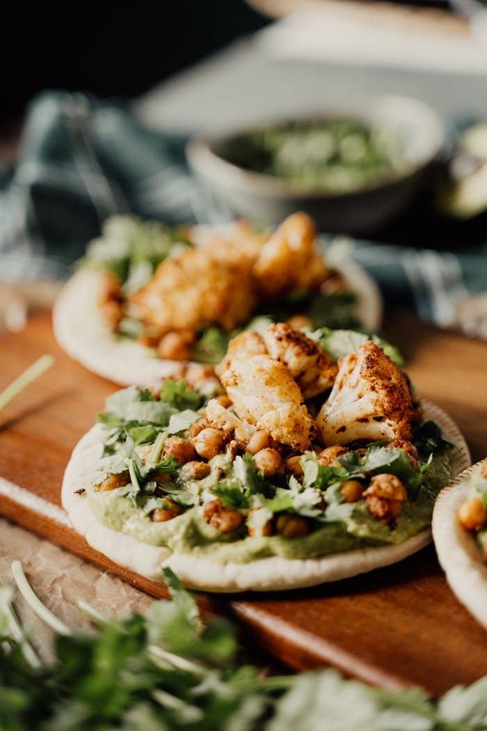 Savor the taste of vegan pitas with roasted cauliflower, chickpeas, and greens, perfect for a healthy meal.